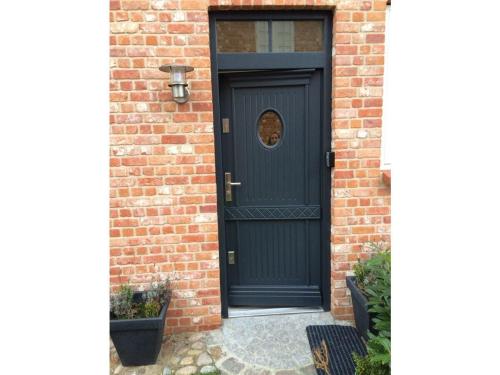 a black door on a brick house with a brick wall at Koje in Sankt Peter-Ording