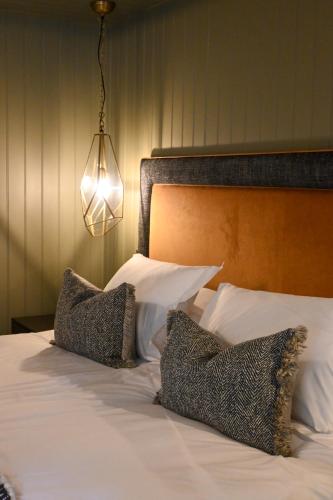 a bedroom with a bed with two pillows and a light at The Apple Inn in Lucker