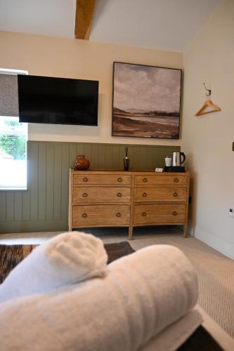 a living room with a tv and a wooden dresser at The Apple Inn in Lucker