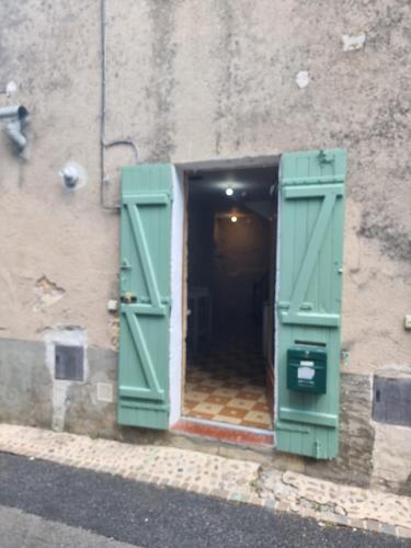 an open door of a building with green shutters at Pechaud 2 in Lalinde