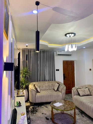 a living room with a couch and a table at Glitz Apartment in Kadobunkuro