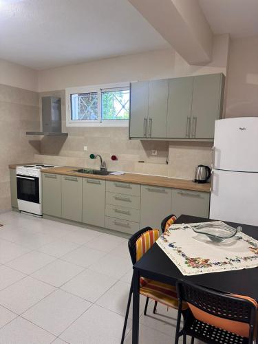 a kitchen with a table and a white refrigerator at Ktima Lena in Órmos