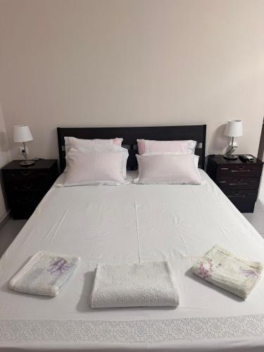 a large white bed with two pillows on it at Ktima Lena in Órmos