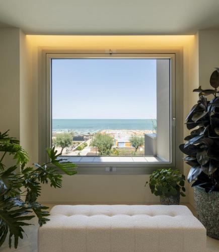 a large window with a white couch in front of it at Opera Suite Hotel Pesaro in Pesaro