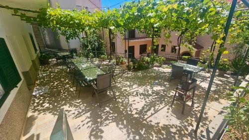 a patio with a table and chairs and trees at Apartmani Vinka in Pisak
