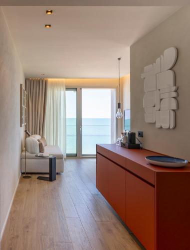 a living room with a desk and a couch at Opera Suite Hotel Pesaro in Pesaro