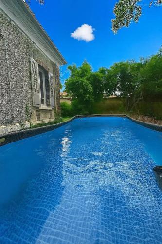 a blue swimming pool in front of a house at Maison spacieuse à Saint-Florentin, 138 m², avec jardin in Saint-Florentin