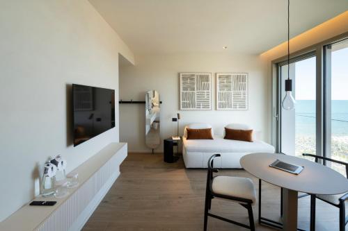 a hotel room with a bed and a table at Opera Suite Hotel Pesaro in Pesaro