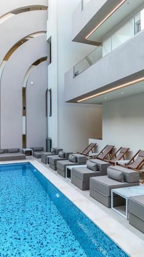 a swimming pool in a building with couches and a swimming pool at Zorbas Lifestyle Hotel in Georgioupolis