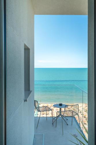 a view of the beach from the balcony of a house at Opera Suite Hotel Pesaro in Pesaro
