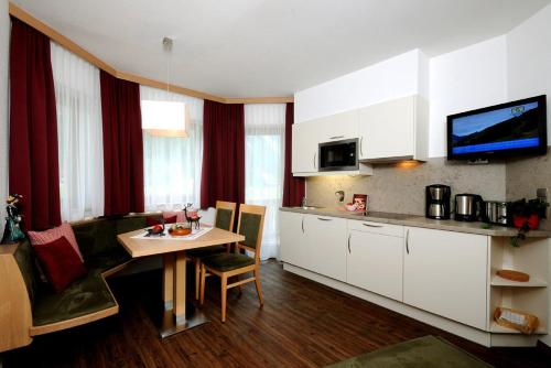 uma cozinha com armários brancos e uma mesa num quarto em Jagdhof Ligedl em Mayrhofen