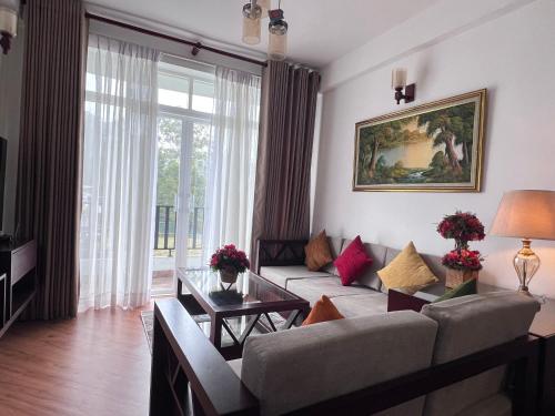 a living room with a couch and a table at Galway Green - Lake View Luxury Apartment, Nuwara Eliya Sri Lanka in Nuwara Eliya