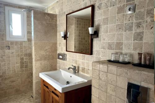 a bathroom with a sink and a mirror at Hôtel Pineto in Biguglia