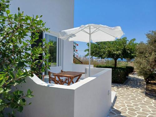 a wooden table and an umbrella on a patio at Dina's Diamond in Agios Prokopios