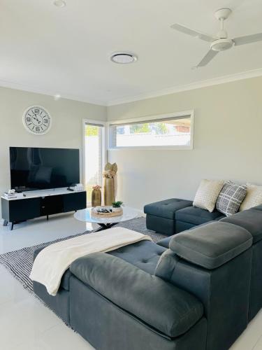 a living room with a couch and a table at Cozy & Spacious 5BR Family Home with Free On-Site Parking in Pendle Hills