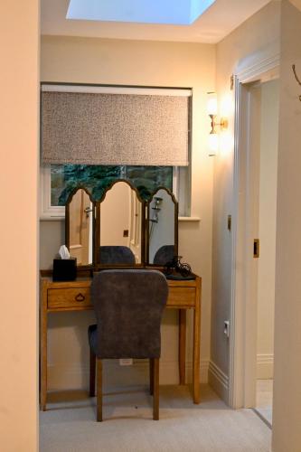 a desk with a mirror and a chair in a room at The Apple Inn in Lucker