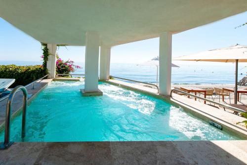 a swimming pool with a view of the ocean at Hôtel Pineto in Biguglia