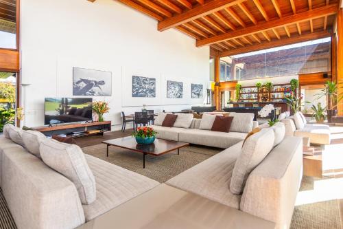 a living room with couches and a flat screen tv at Zendaya Resort Beach Sport & Spa in Búzios