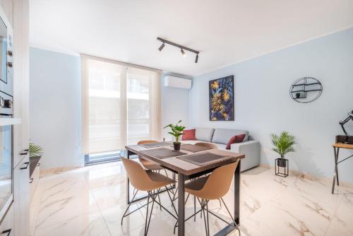 Una sala de estar blanca con una mesa y sillas. en Stylish 2BR Escape in St Julians, en San Julián