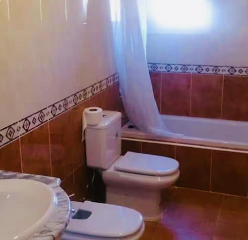 a bathroom with a toilet and a sink and a tub at Espectacular chalet 7 personas in Lepe