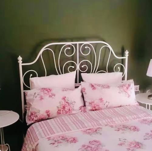 a bed with pink and white sheets and pillows at Espectacular chalet 7 personas in Lepe