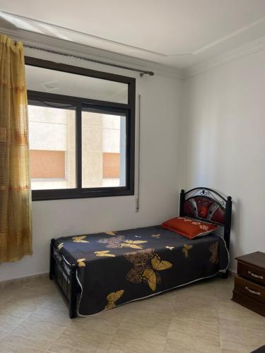 a bed in a room with a window at Vancouver appartement in Nador