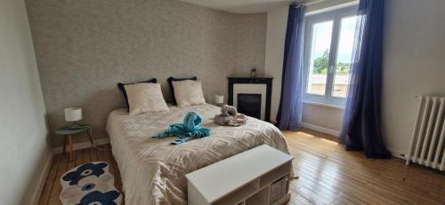 a bedroom with a bed with a teddy bear on it at Villa Zelly in Sancergues