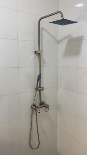 a shower with a shower head on a white wall at 4 bedroom apartment in Igaun