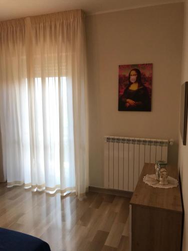a living room with white curtains and a table at Residenza delle Rose in Lamezia Terme