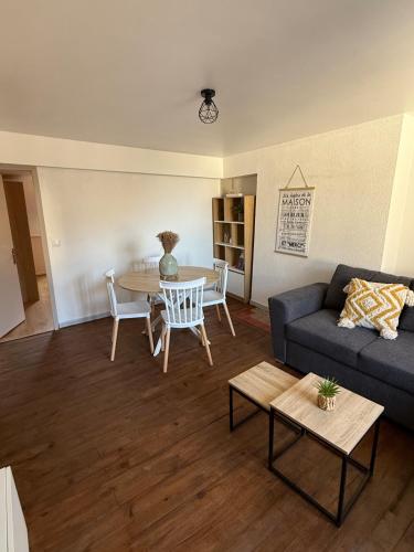 een woonkamer met een bank en een tafel bij Le Nid Dolois in Dole
