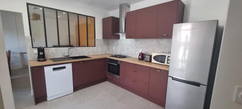 - une cuisine avec des placards violets et un réfrigérateur blanc dans l'établissement Maison 3 chambres, à Gouaix