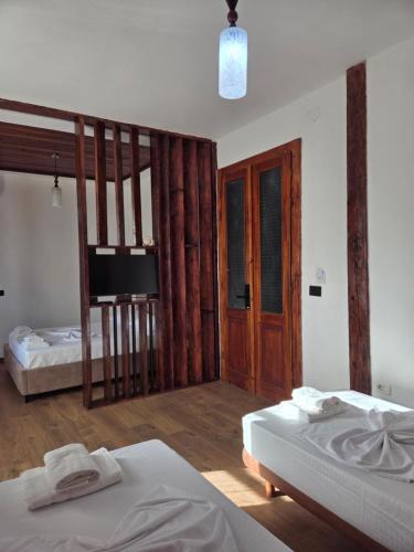 a bedroom with two beds and a tv in it at Antique House Muradie in Vlorë