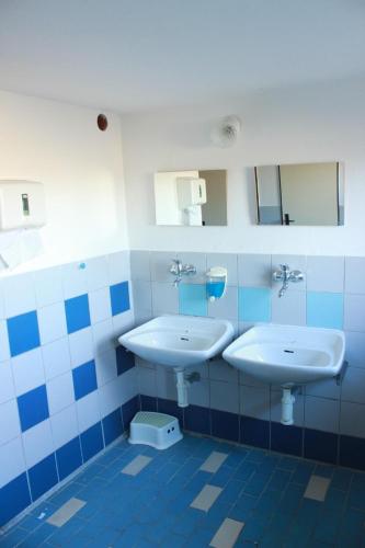 a bathroom with two sinks and mirrors on the wall at Chata Luna in Orlické Záhoří 