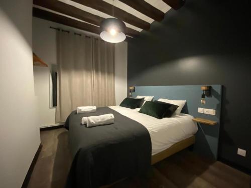 a bedroom with a large bed with a black wall at L'écrin de Loire by Saumur Signature in Saumur