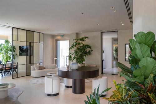 a living room with a table and some plants at Opera Suite Hotel Pesaro in Pesaro