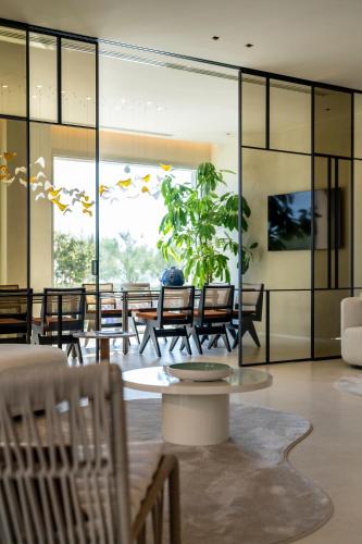 a room with chairs and a table and a potted plant at Opera Suite Hotel Pesaro in Pesaro