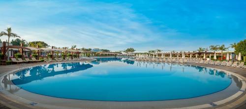 a pool at a resort with chairs and condos at Baia Lara Hotel in Lara