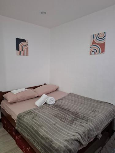 a bedroom with a bed with two towels on it at Pearl staycation in Buaya