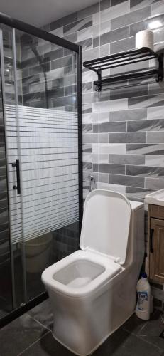 a bathroom with a toilet and a glass shower at Pearl staycation in Buaya