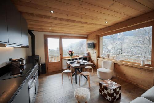 une cuisine et un salon avec une table et des chaises dans l'établissement Chalet Jeane proche du Centre ville de Megève, à Megève