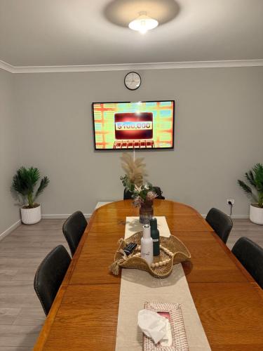 a conference room with a wooden table and a television at J&R Home, A Gippsland Getaway in Jeeralang Junction