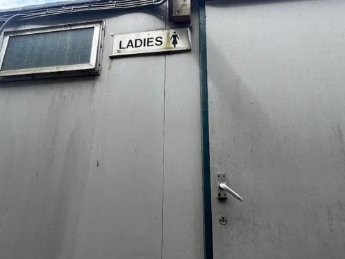 a sign on the side of a building that says ladies at Black Bridge Cabin in Lyonshall