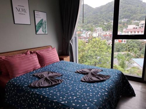 a bedroom with a bed with towels on it at The Deck Condo Patong with mountain view in Patong Beach