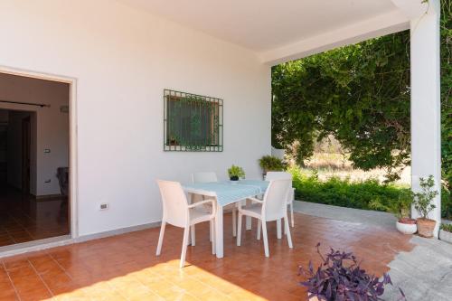 a dining room with a blue table and white chairs at Casa Domitia in Latiano