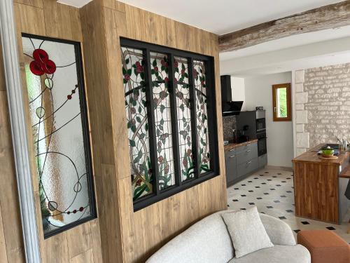 un salon avec un canapé et des vitraux dans l'établissement La bergerie, à Villacerf