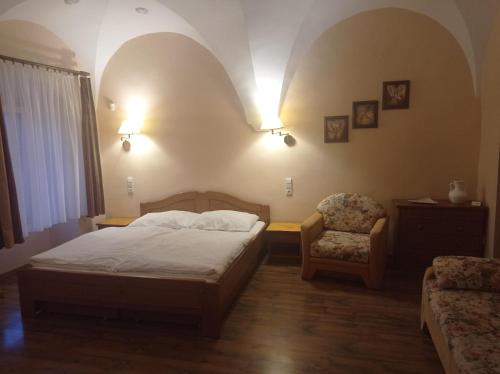 a bedroom with a bed and a chair and lights at Apartmany SLOS in Banská Bystrica