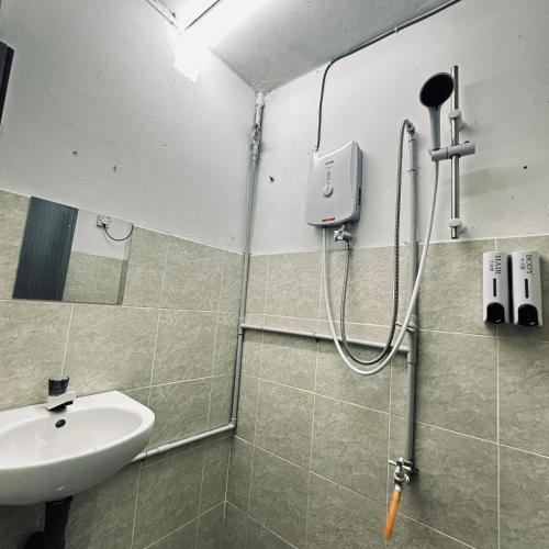 a bathroom with a sink and a shower at Hey Rest Up with shared bathroom in Ipoh