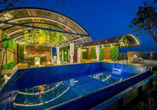 ein Haus mit einem Swimmingpool vor einem Gebäude in der Unterkunft Hotel K2 By L Elegant Advant and Sector 143B in Noida