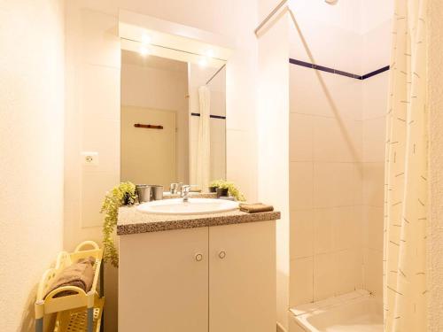 une salle de bain blanche avec un lavabo et une douche dans l'établissement Maison au centre, 4 pers, parking, animaux, près du téléphérique - FR-1-296-437, à Saint-Lary-Soulan