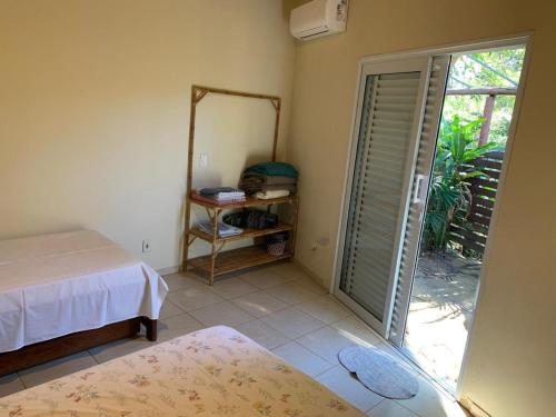 a bedroom with a bed and a mirror and a door at Sossego Homestay - Chapada dos Guimarães in Chapada dos Guimarães